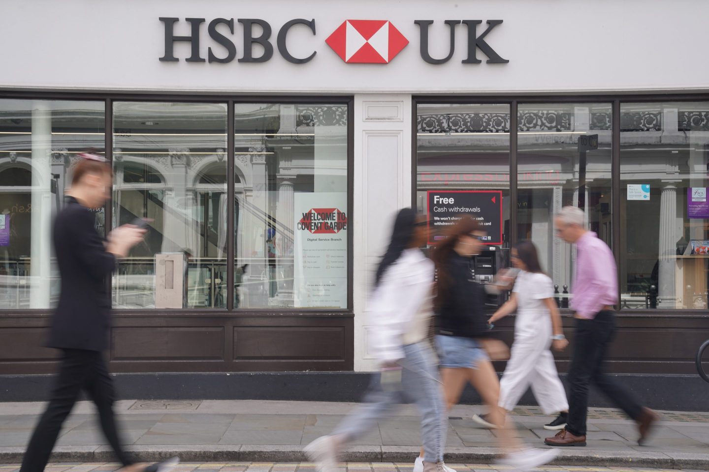 people walking outside an HSBC bank branch in London