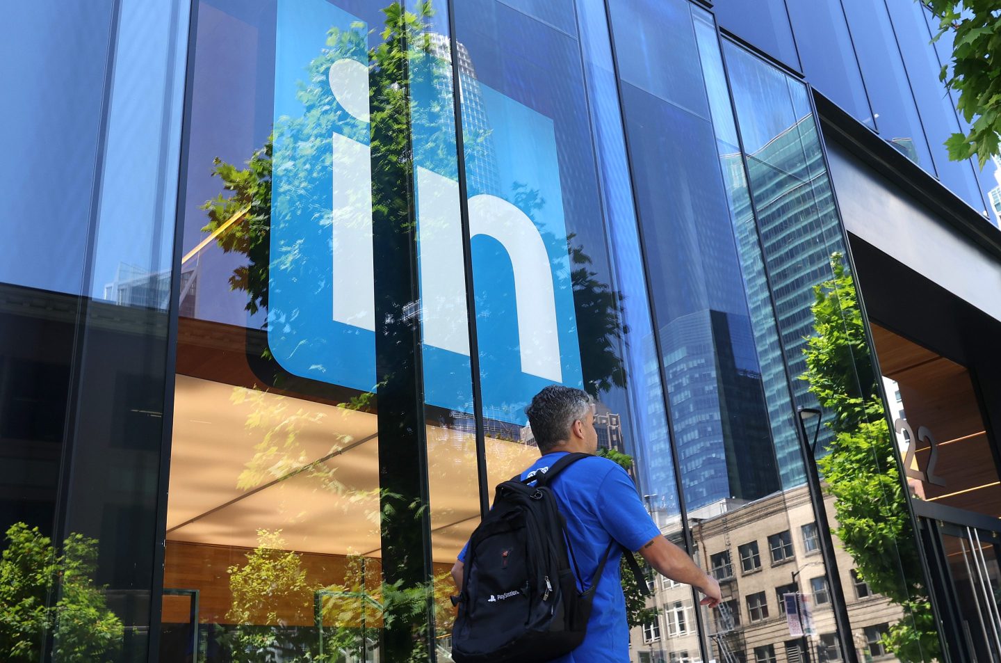 A pedestrian walks by a sign at a LinkedIn office on July 26, 2023 in San Francisco, California.