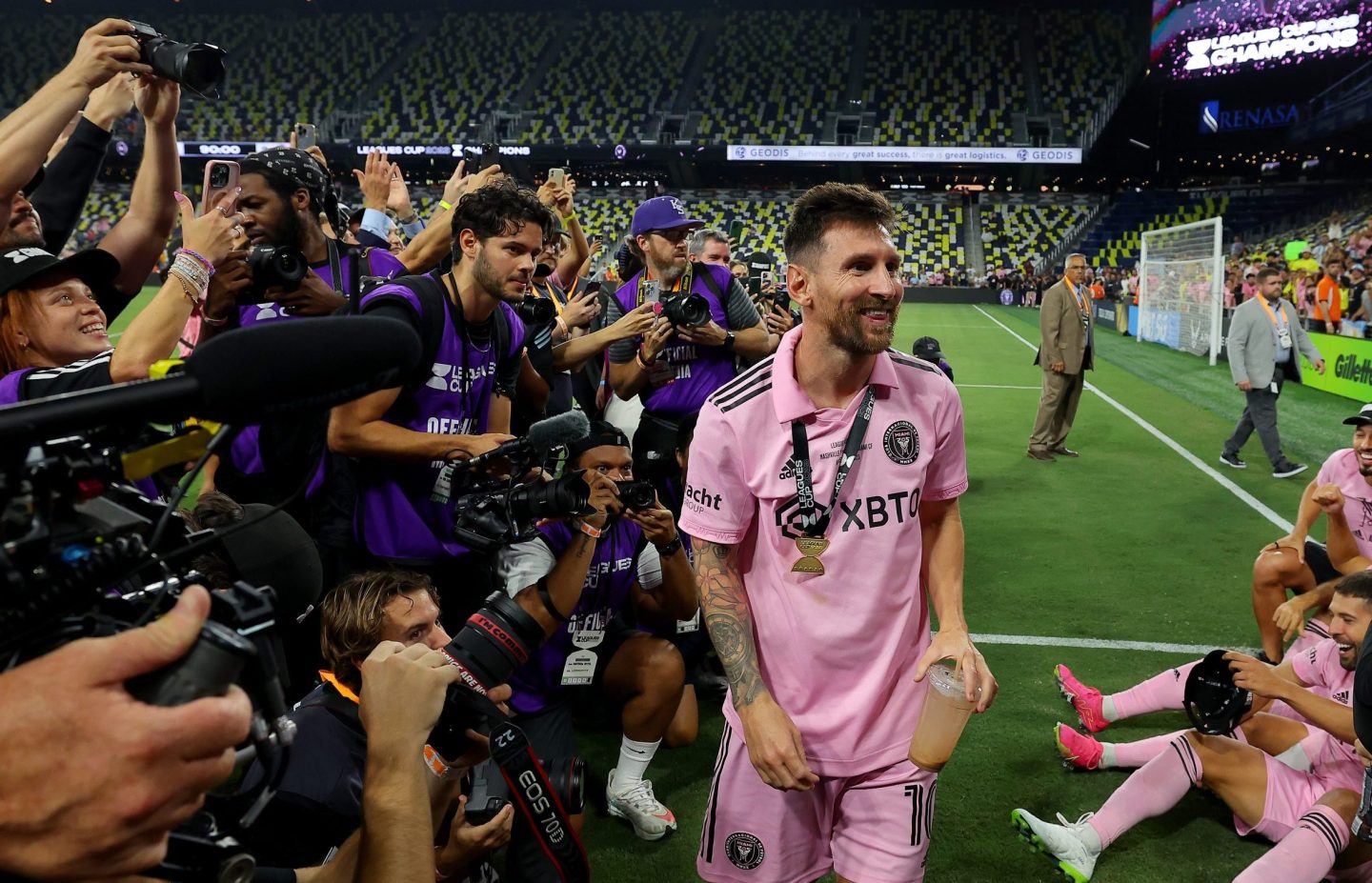 Lionel Messi surrounded by cameramen.