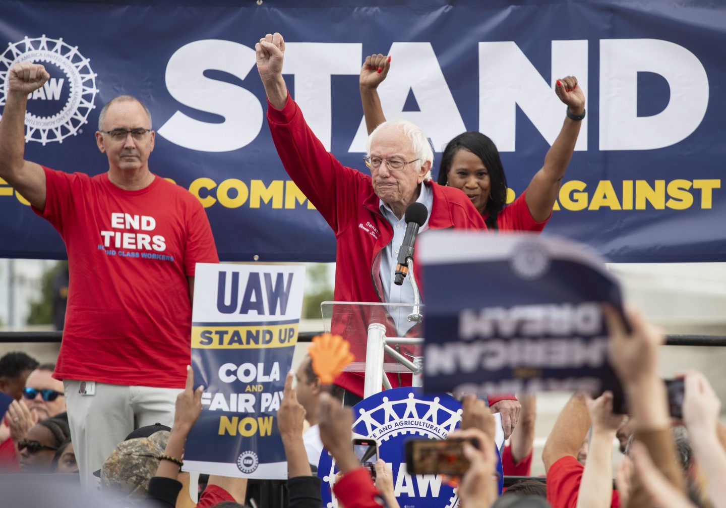 Bernie Sanders on the UAW picket line with his fist raised in a sign of solidarity