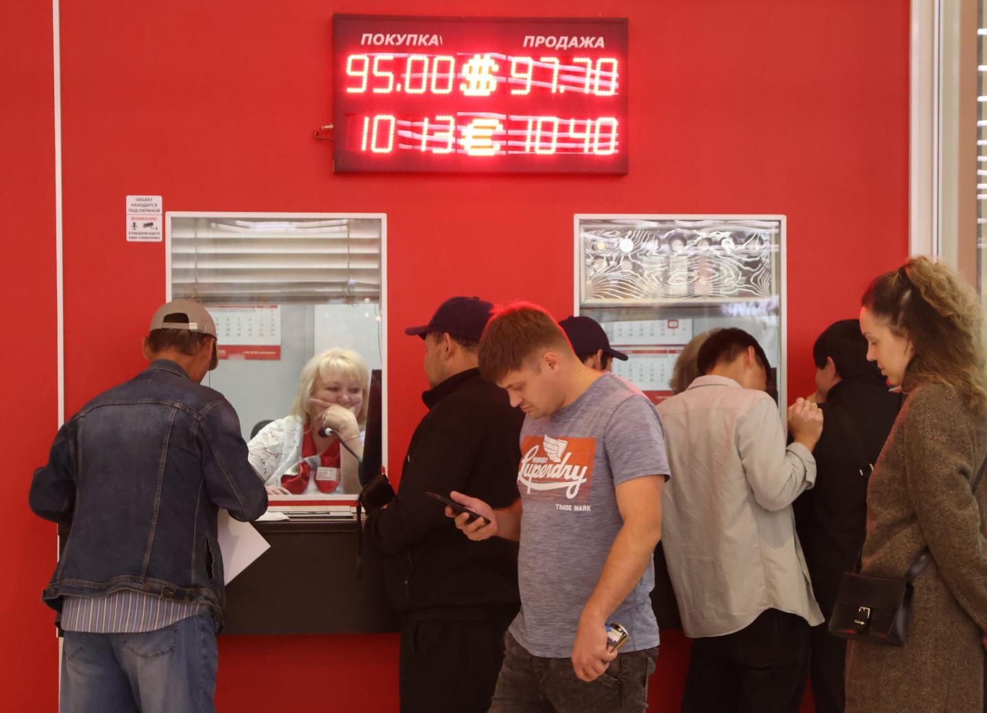 people outside a currency exchange booth