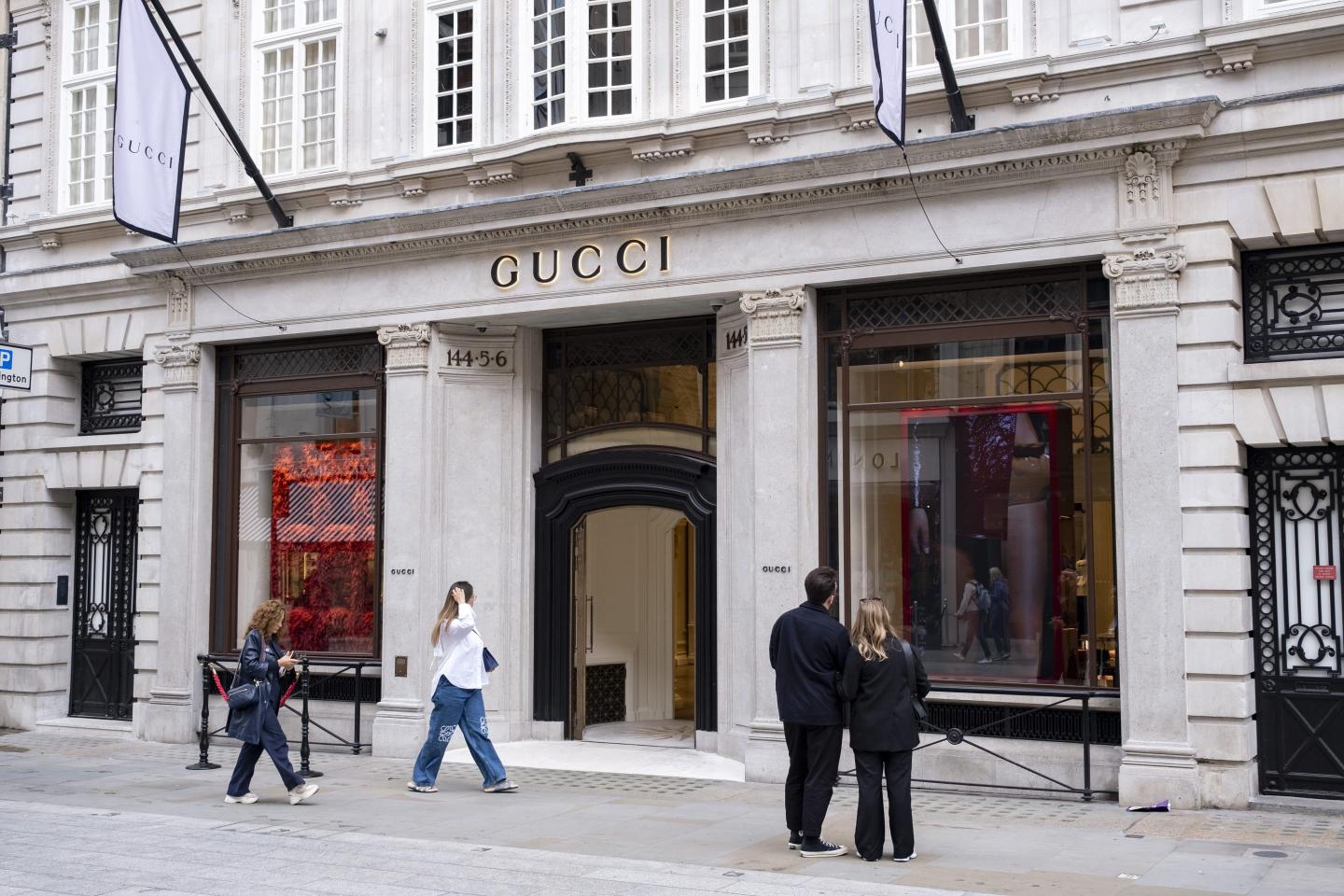 people walking outside a Gucci showroom