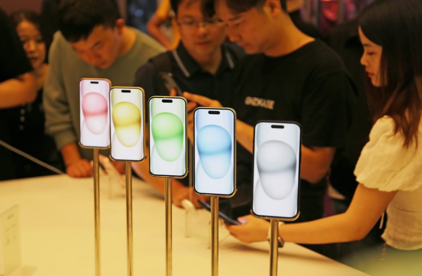 Customers experience the iPhone 15 series phones at an Apple store in Shanghai.