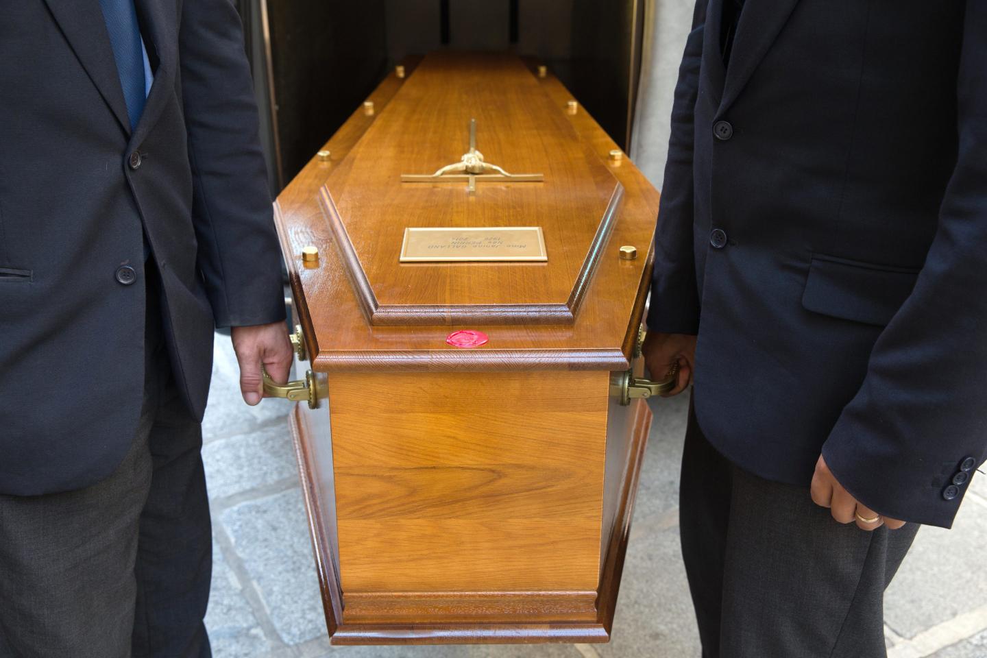 Pallbearers carrying a wooden casket