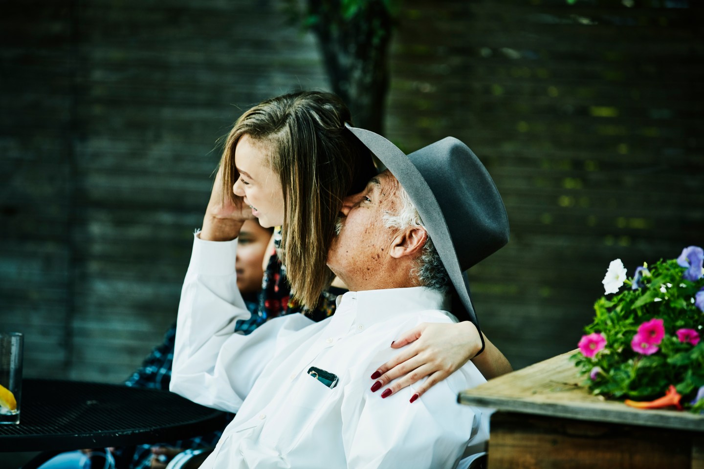 Photo of grandfather kissing his granddaughter at a family gathering