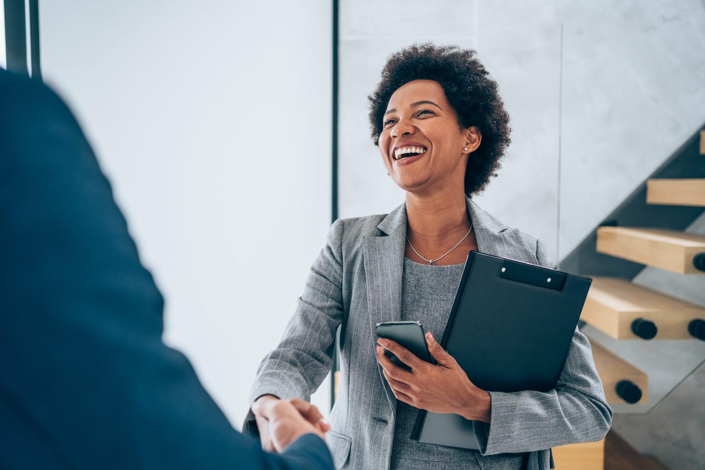 Photo of business people shaking hands in an office.