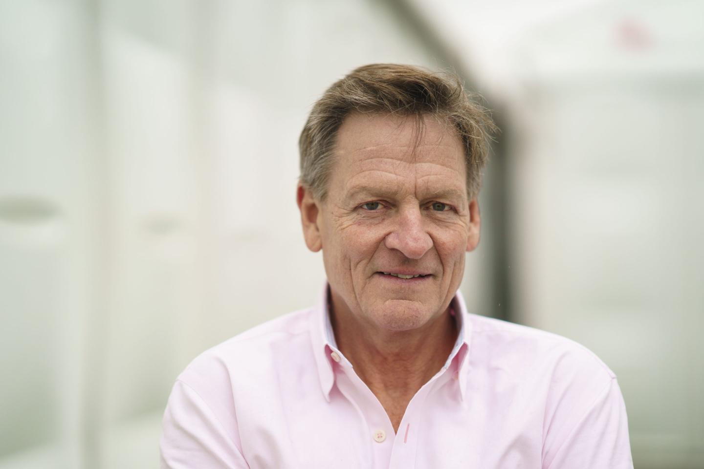 white man in pink collared shirt