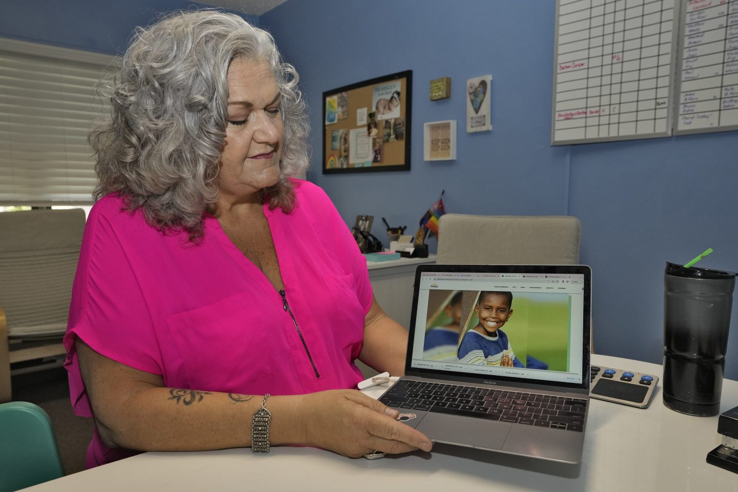 Social worker looks at computer screen with an image of her adopted son