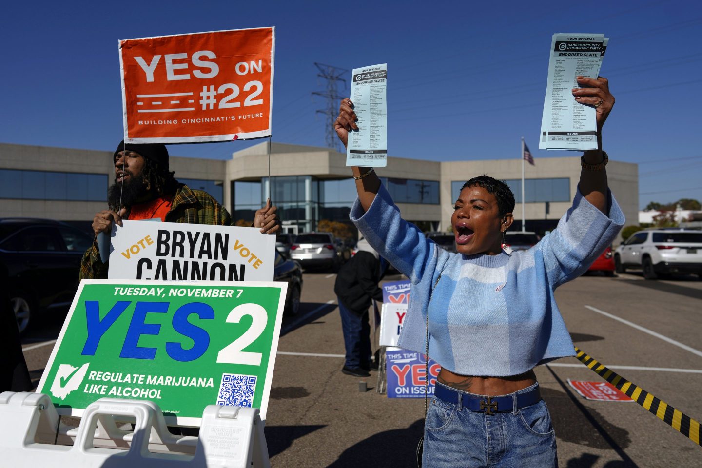 Nikko Griffin, left, and Tyra Patterson, call out to arriving voters in the parking lot of the Hamilton County Board of Elections during early in-person voting in Cincinnati.