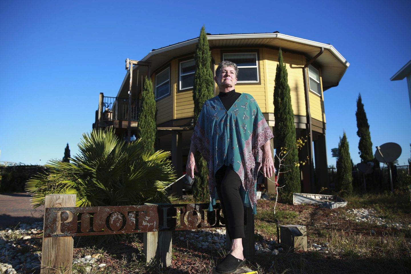 Woman stands in front of her hurricane-resistant home