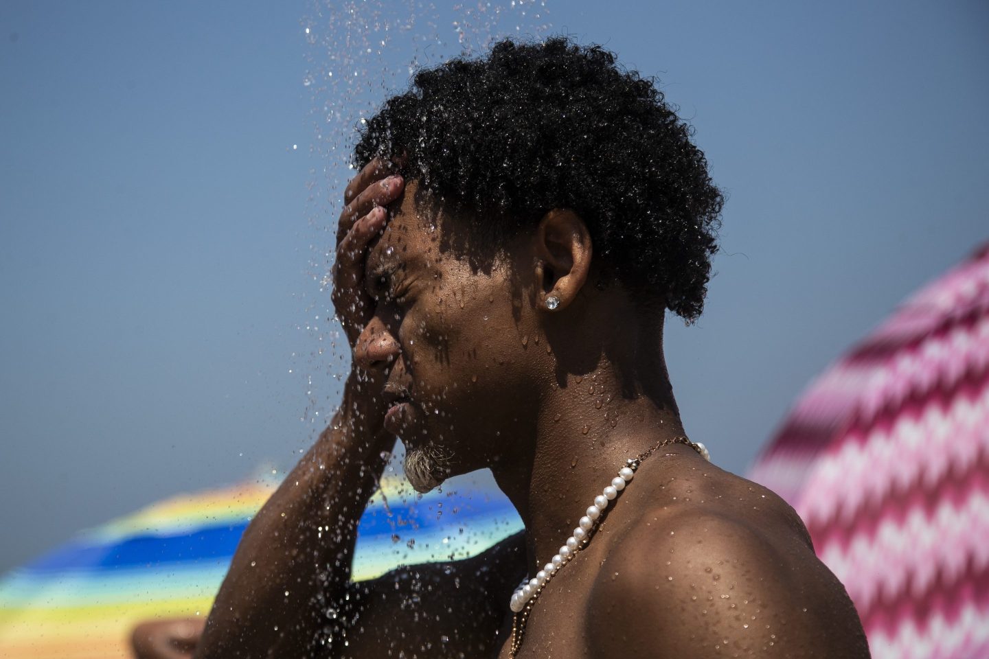 A man cools off in a shower at a beach.