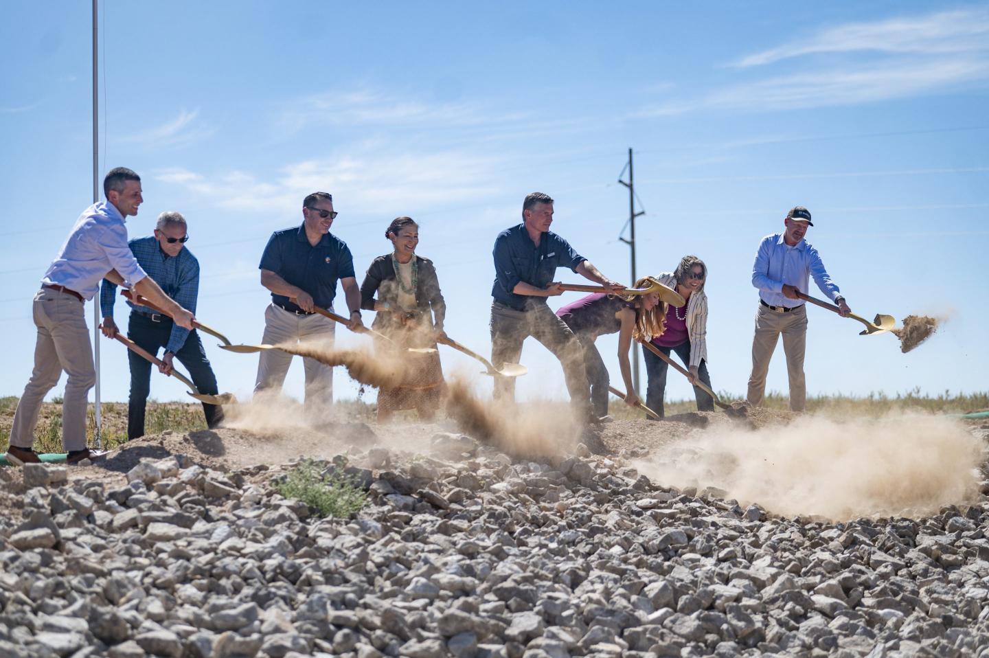 Dignitaries break ground with shovels on the site of a new transmission line