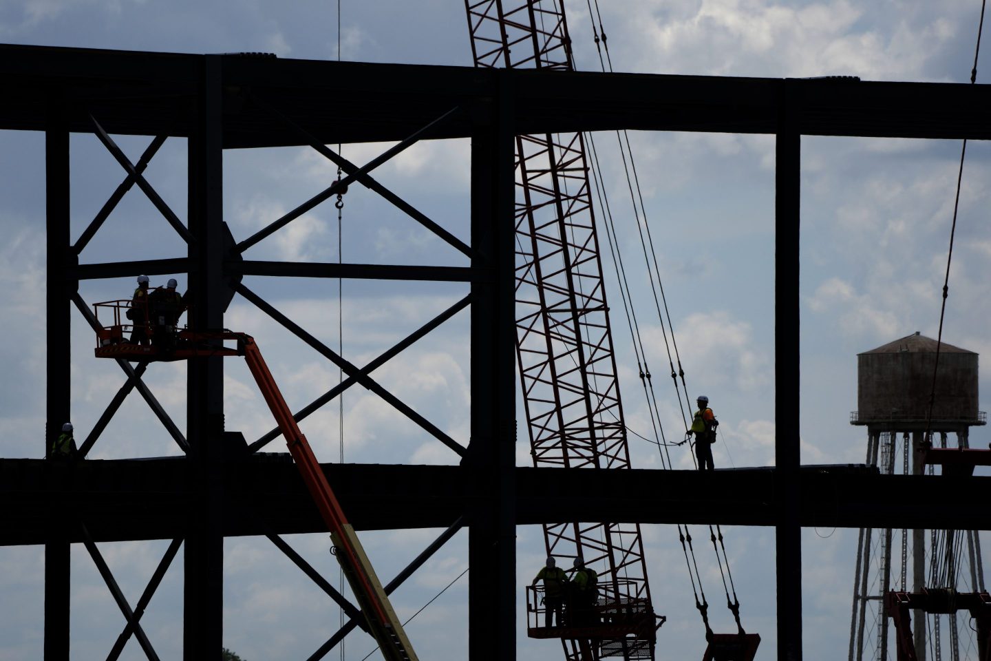 Iron workers construct the framework of a battery plant