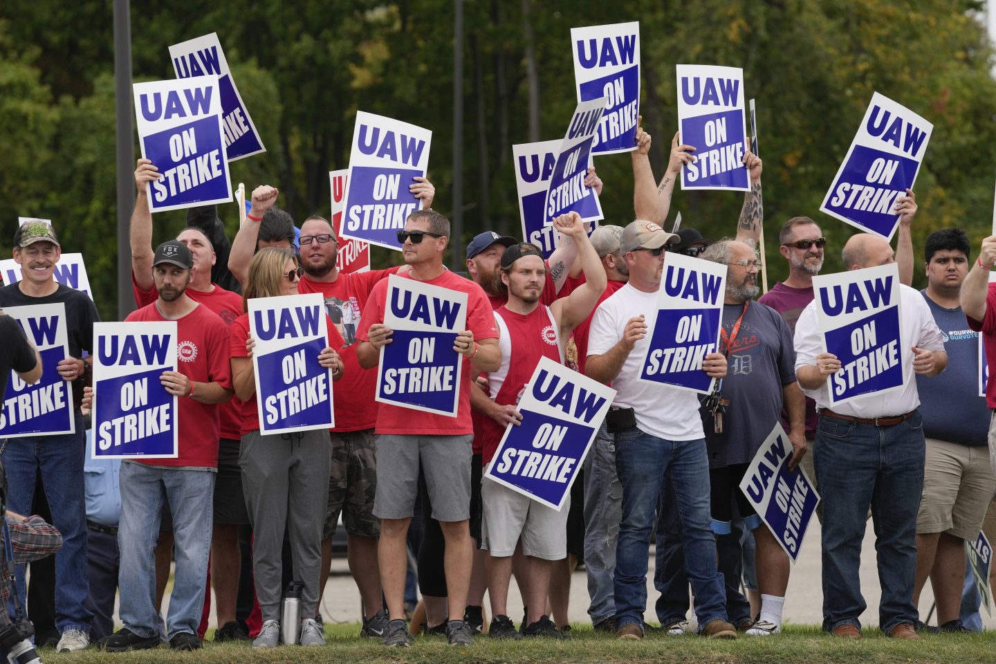 United Auto Workers members hold picket signs near a General Motors assembly plant in Delta Township, Mich., on Sept. 29, 2023.