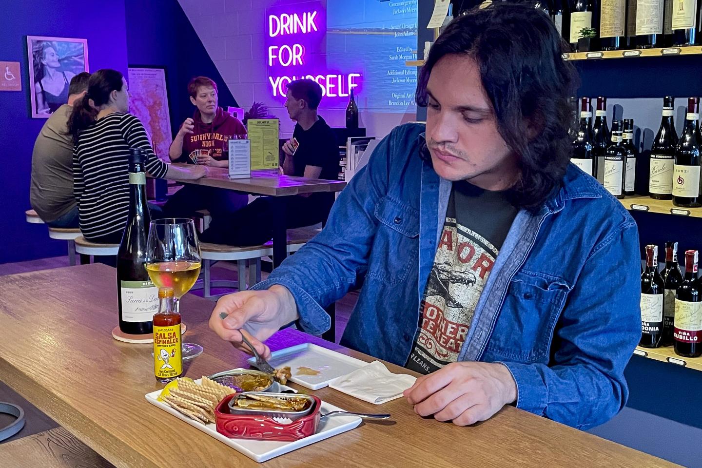 A person eating tinned fish