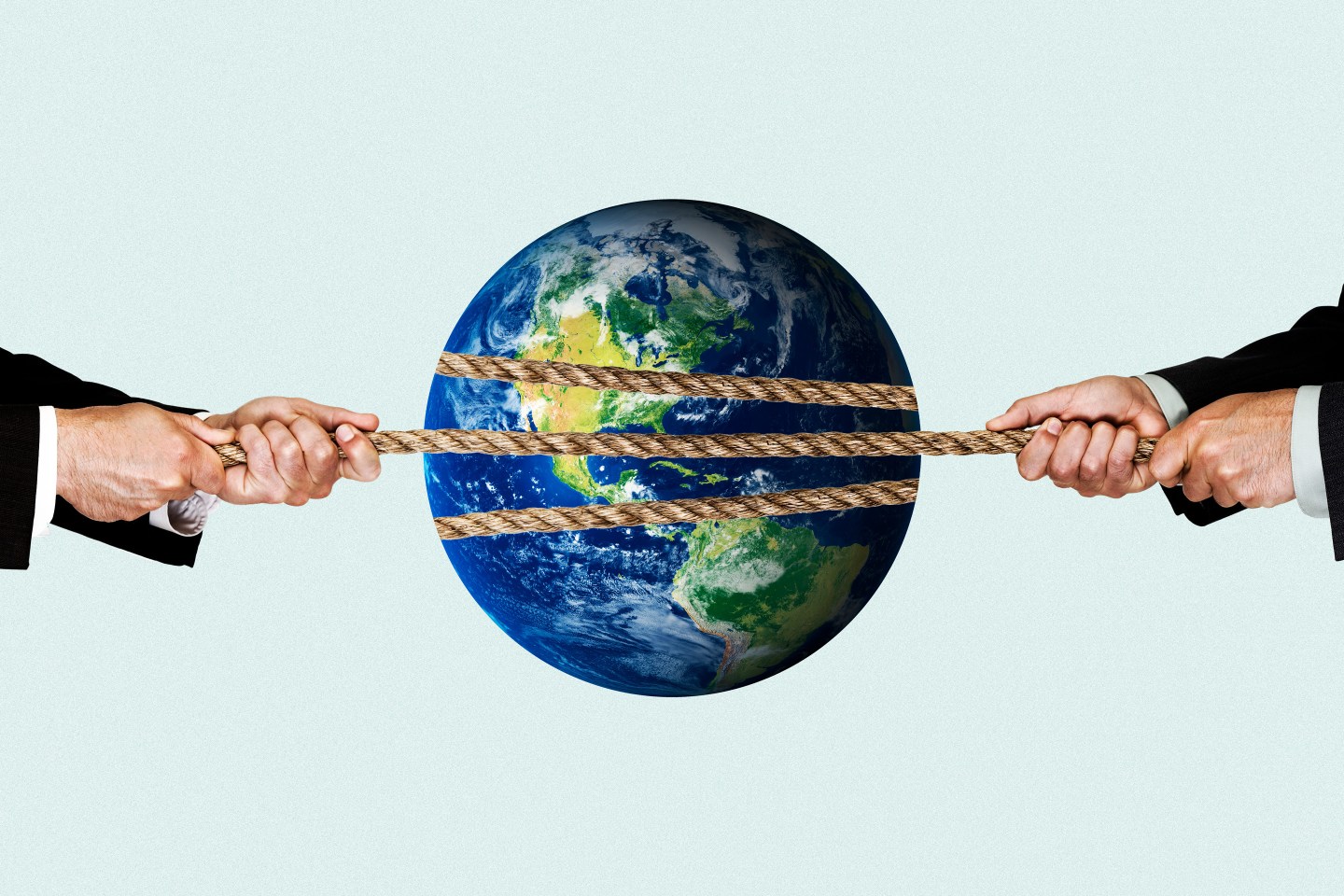 Businessmen having a tug of war with a globe in the middle of the rope.