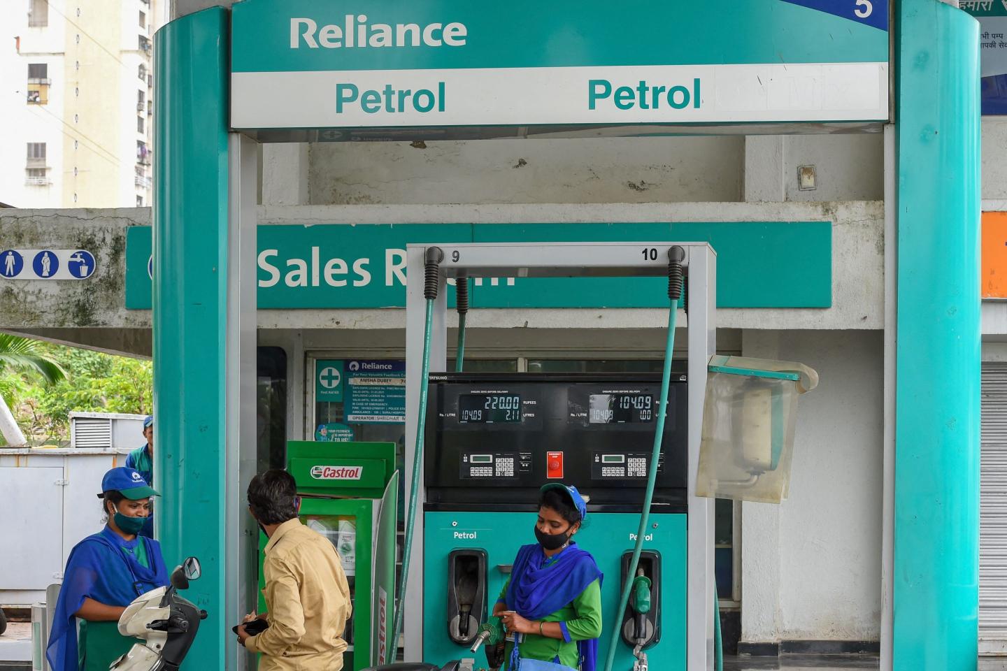 Employees attend a customer at the Reliance Industries (Europe’s top supplier of Indian diesel) Petrol pump in Navi Mumbai.