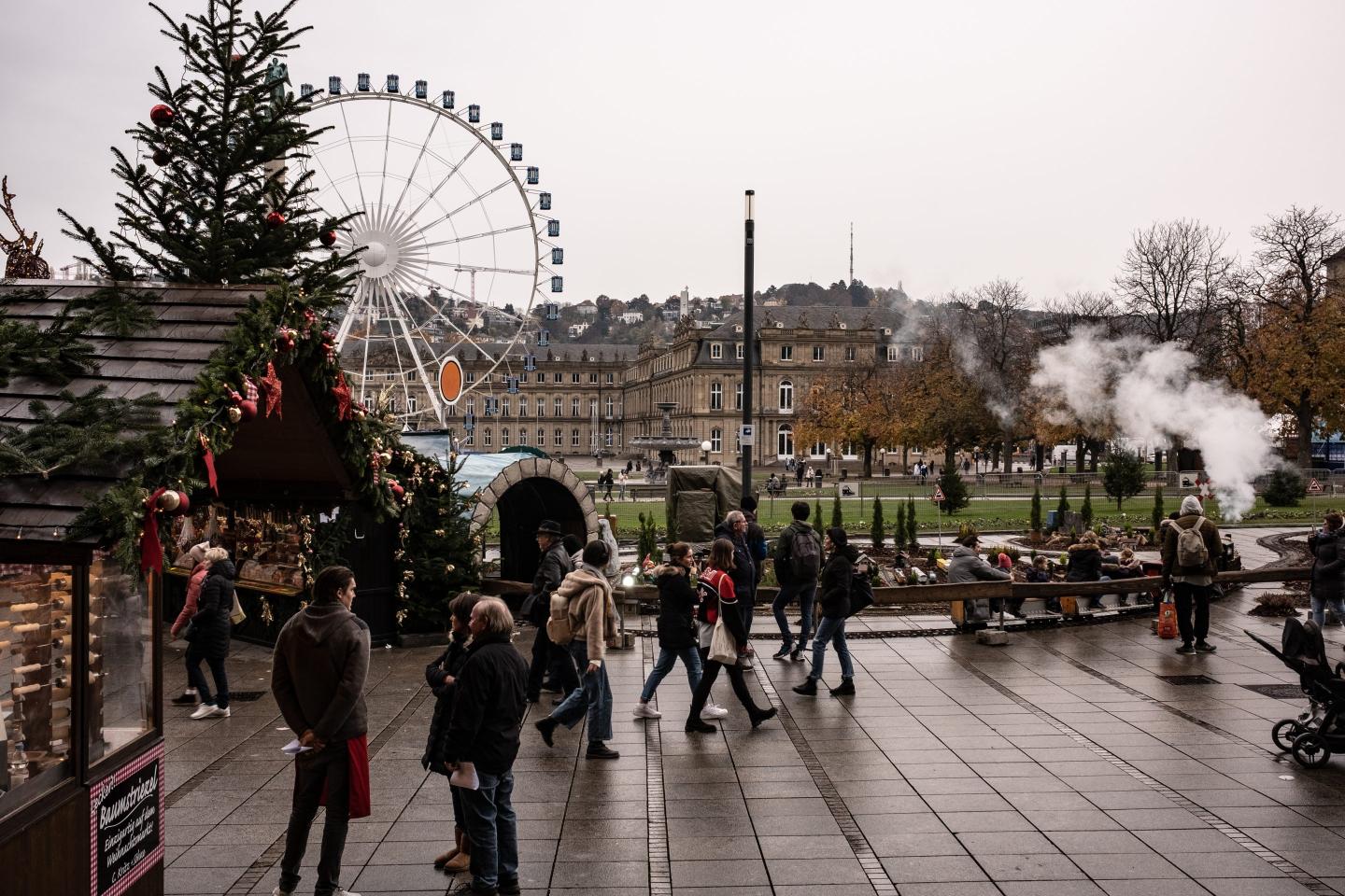 people walking on a buy pathway with a giant wheel in the background