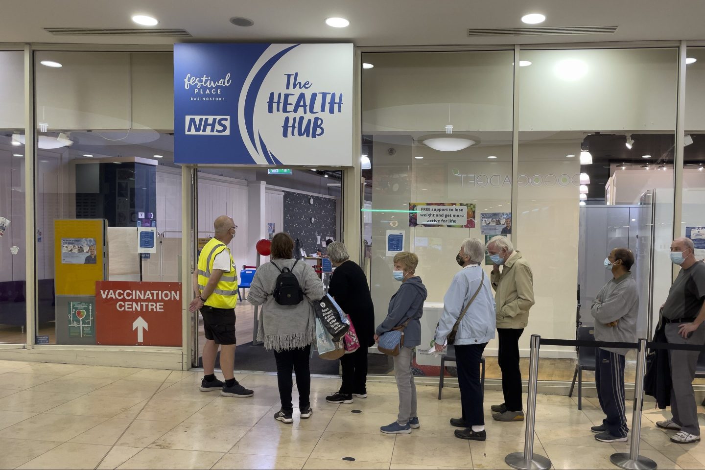 People waiting outside a clinic with masks on
