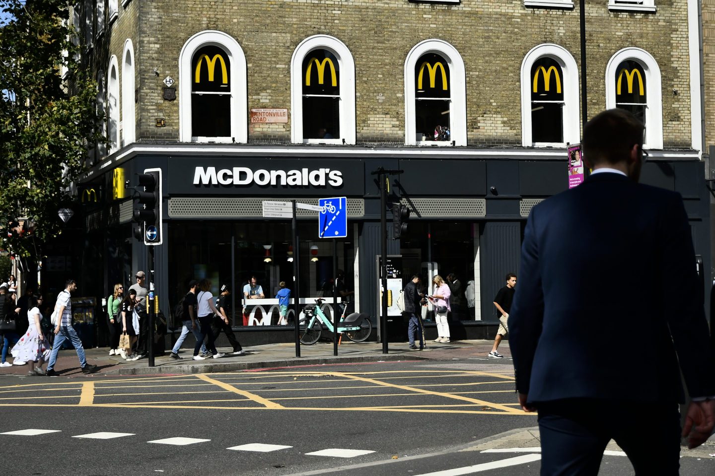 PEOPLE WALKING ON A STREET, MCDONALDS RESTAURANT AT THE CORNER