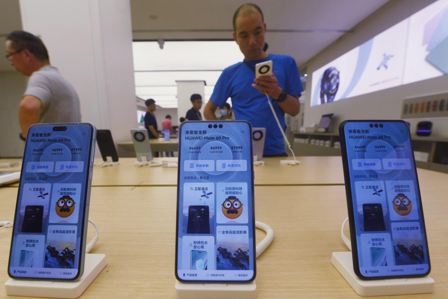 Customers check out Huawei's Mate 60 Pro phone at a Huawei store in Hangzhou, East China's Zhejiang province, Sept 14, 2023.