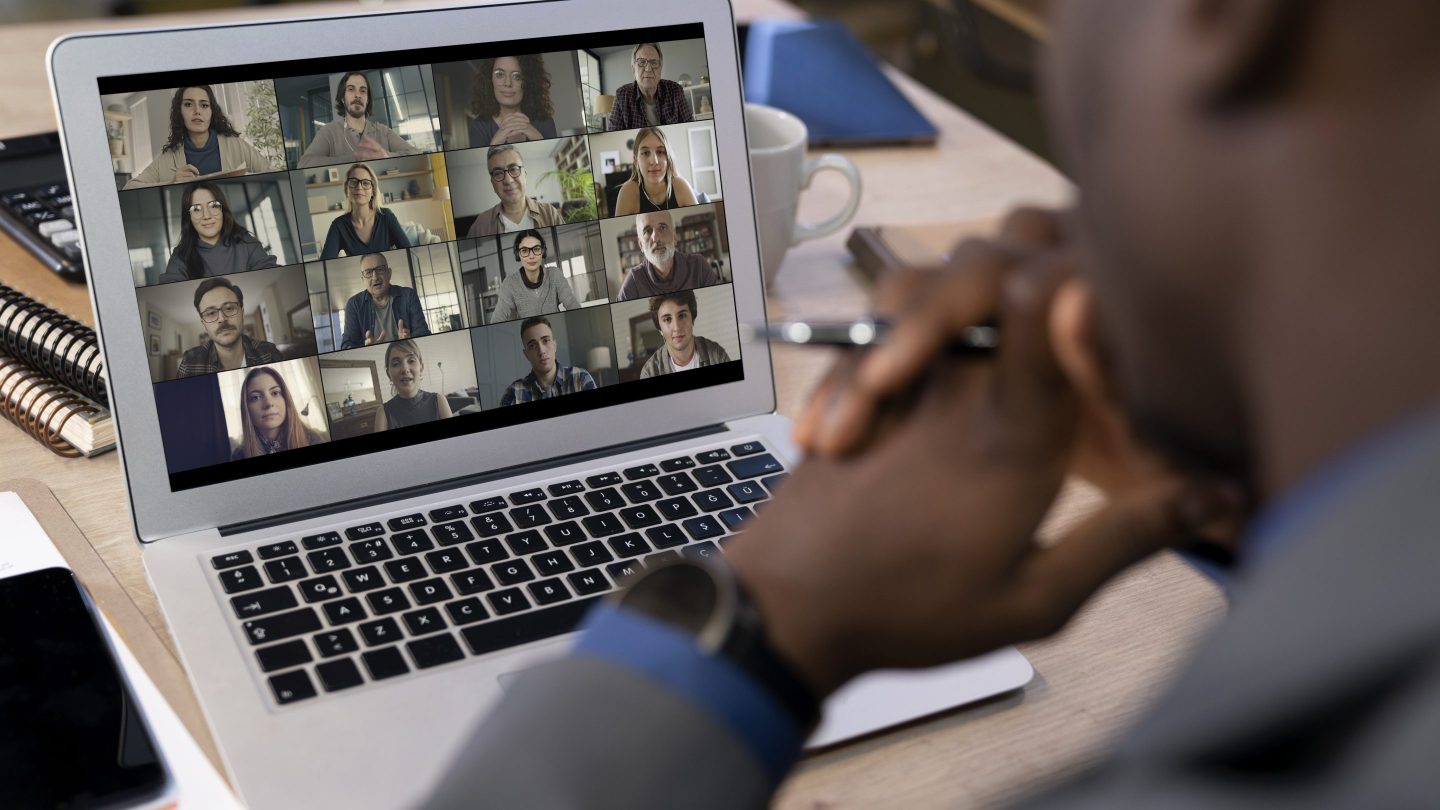 A man is seen taking part in a virtual work meeting.