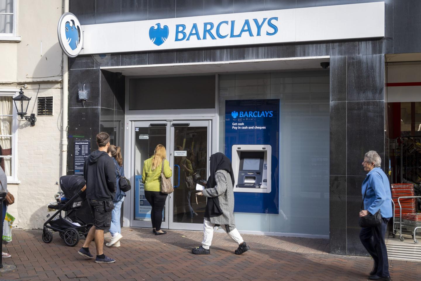 people walking outside a Barclays Bank branch