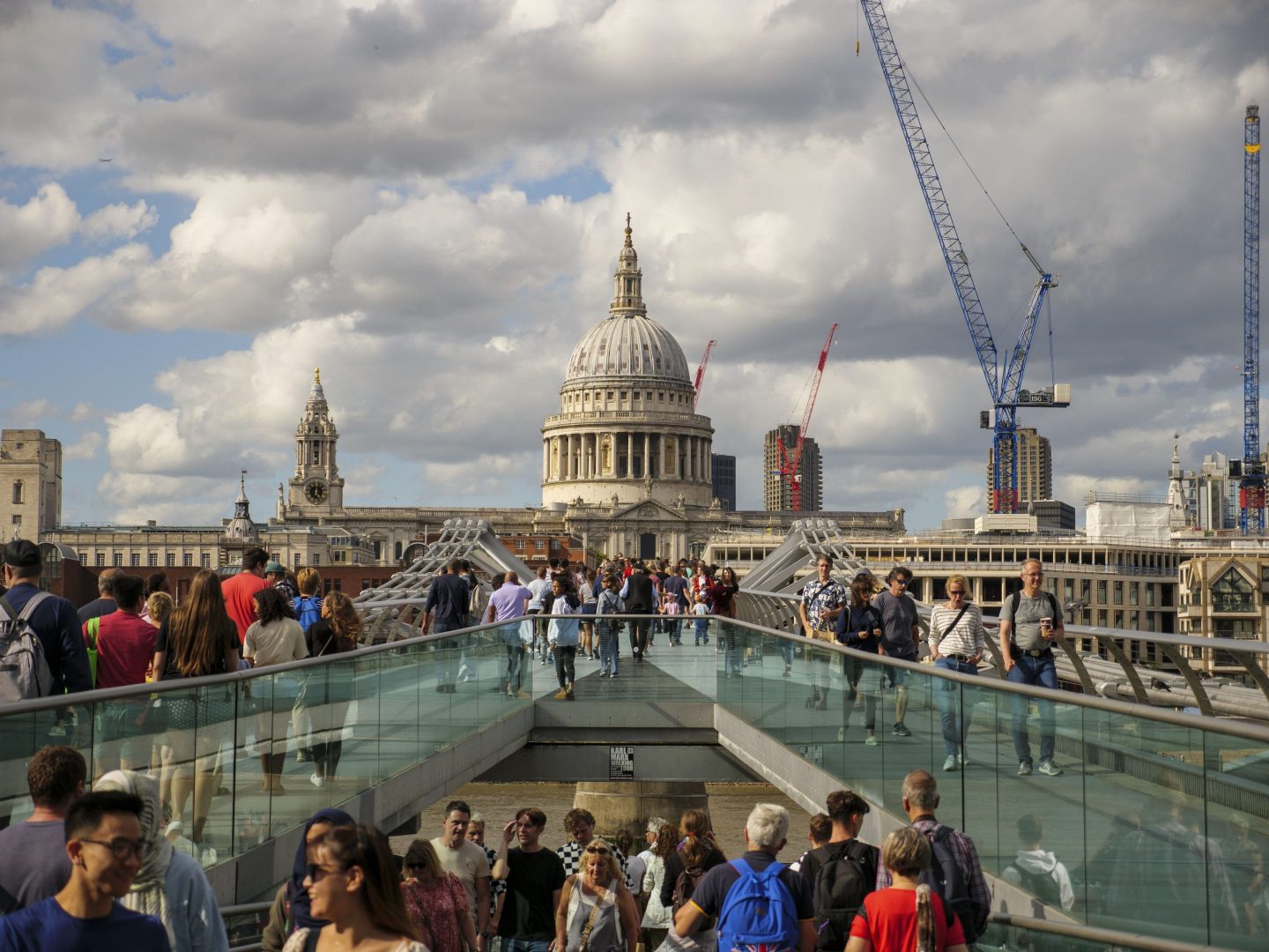 PEOPLE WALKING ON MILLENNIUM BRIDGE WITH ST PAULS CATHEDRAL IN THE BACKGROUND