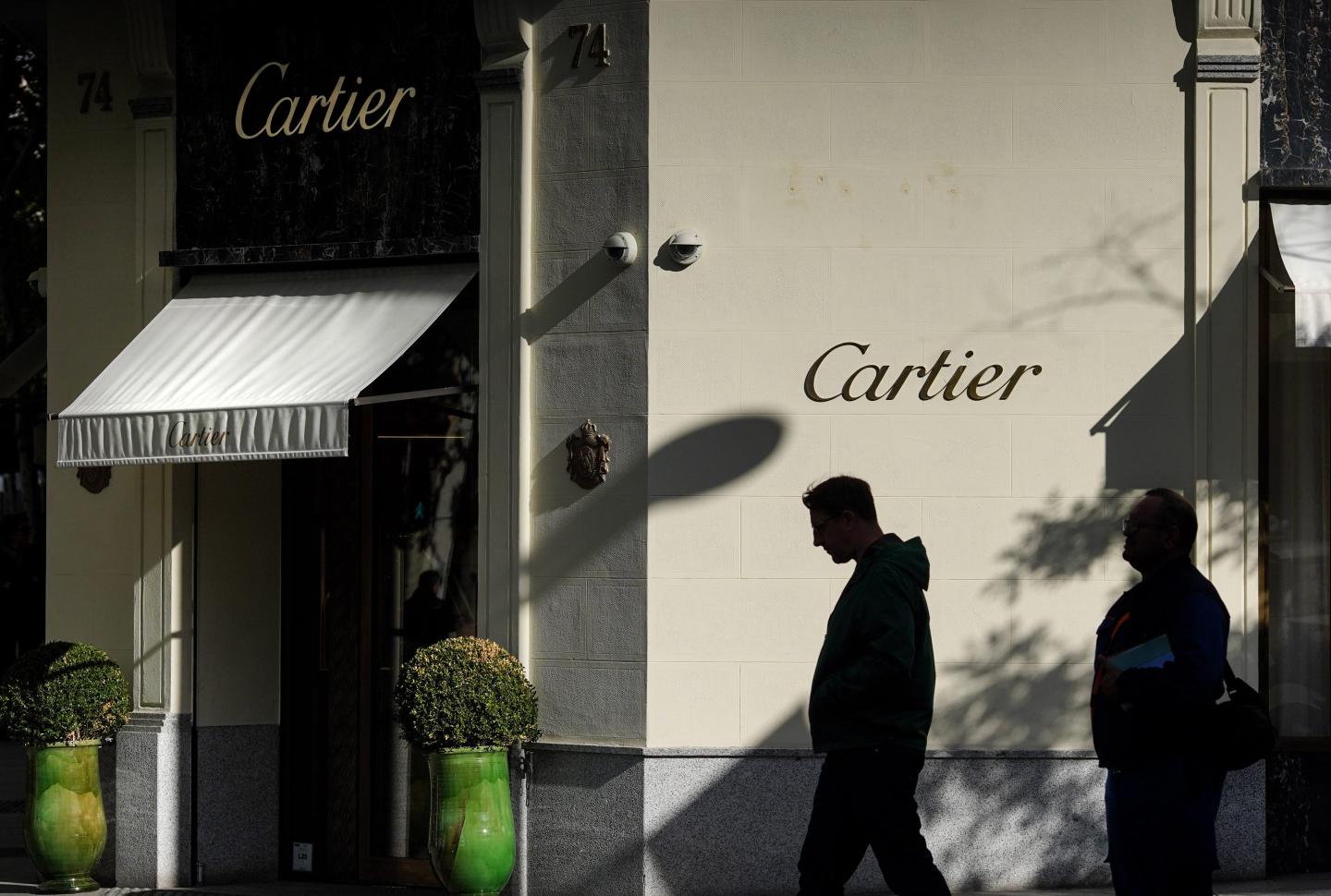 people walking outside a Cartier store