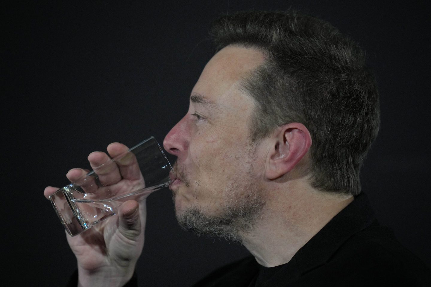 Elon Musk drinking a glass of water