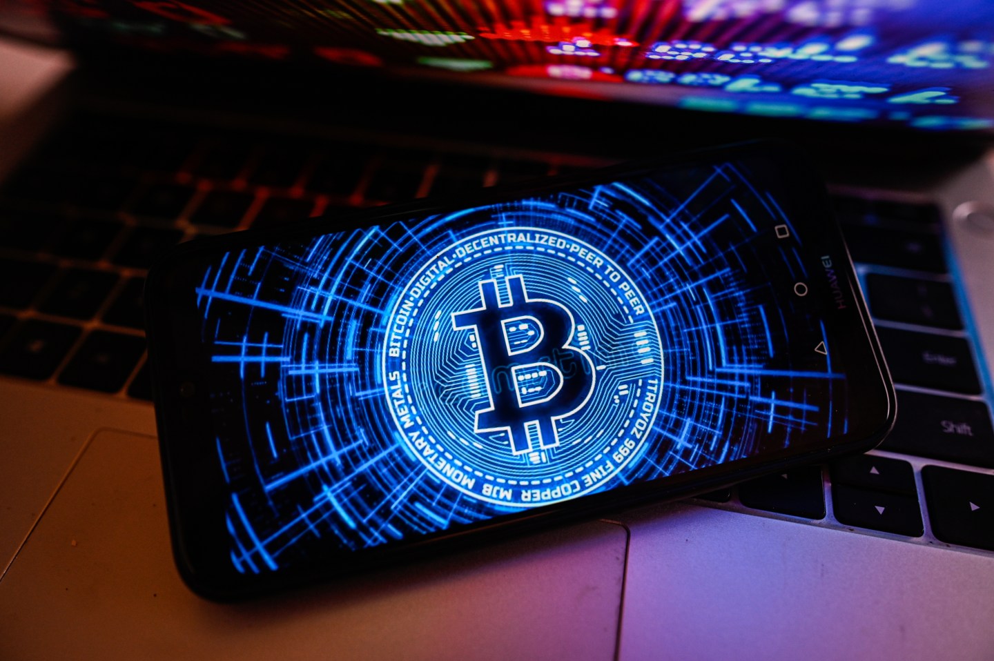 Bitcoin logo is displayed on a smartphone