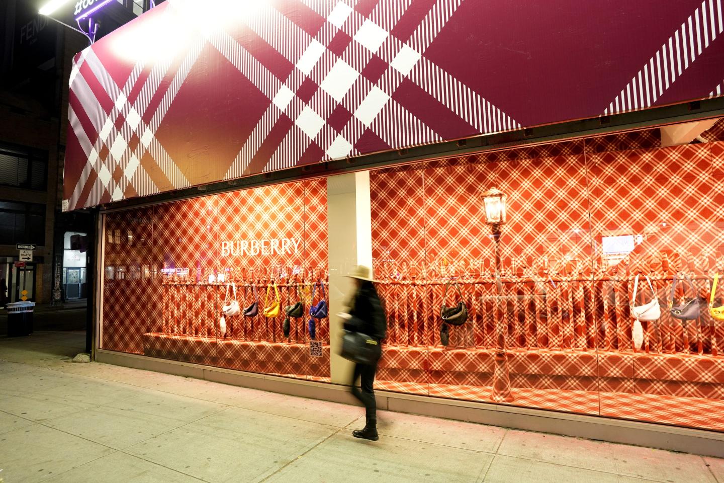 person walking outside a burberry storefront