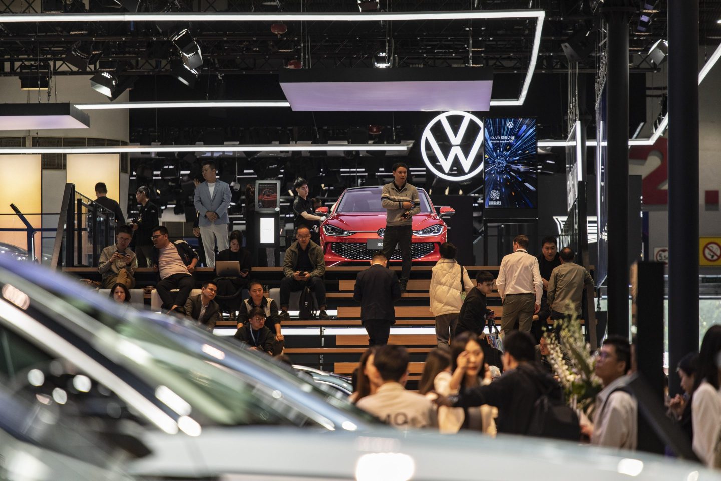 crowds scattered in a room against Volkswagen logo
