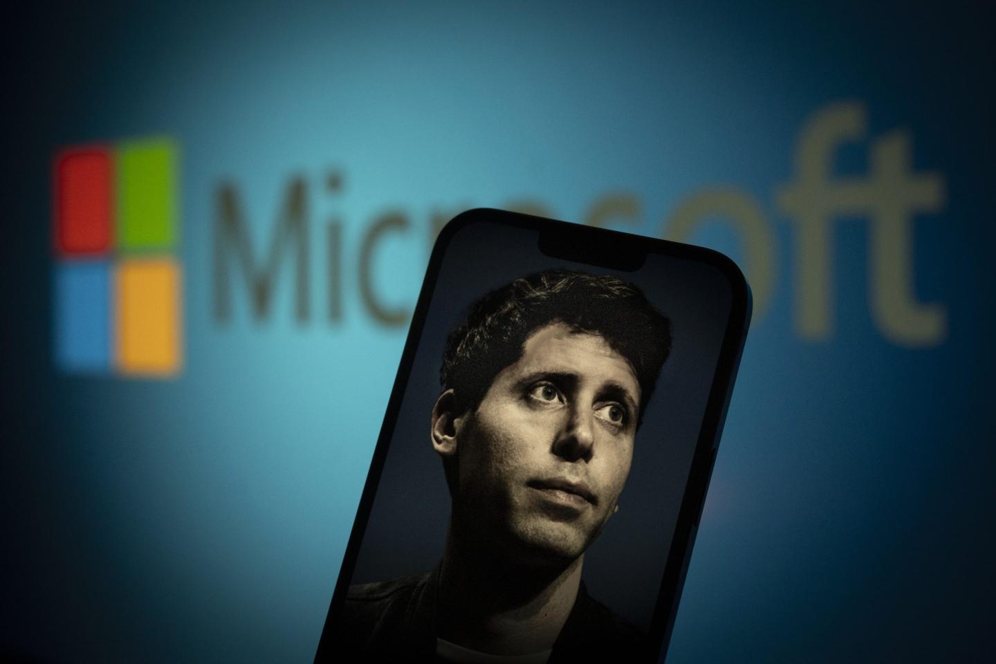 An image of OpenAI CEO Sam Altman on a phone screen, superimposed over Microsoft's logo.