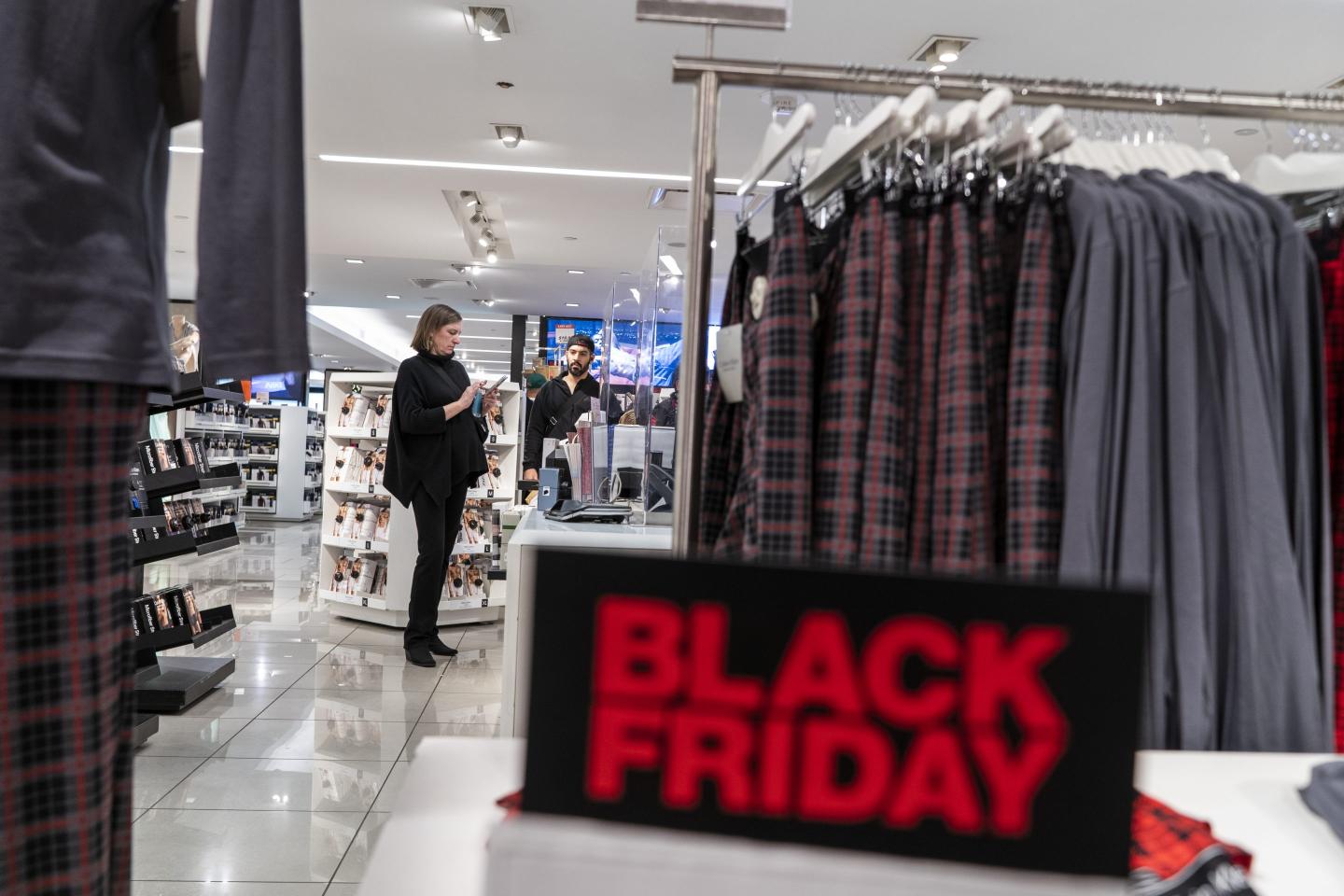 People look for clothing inside of a department store in preparation for Black Friday