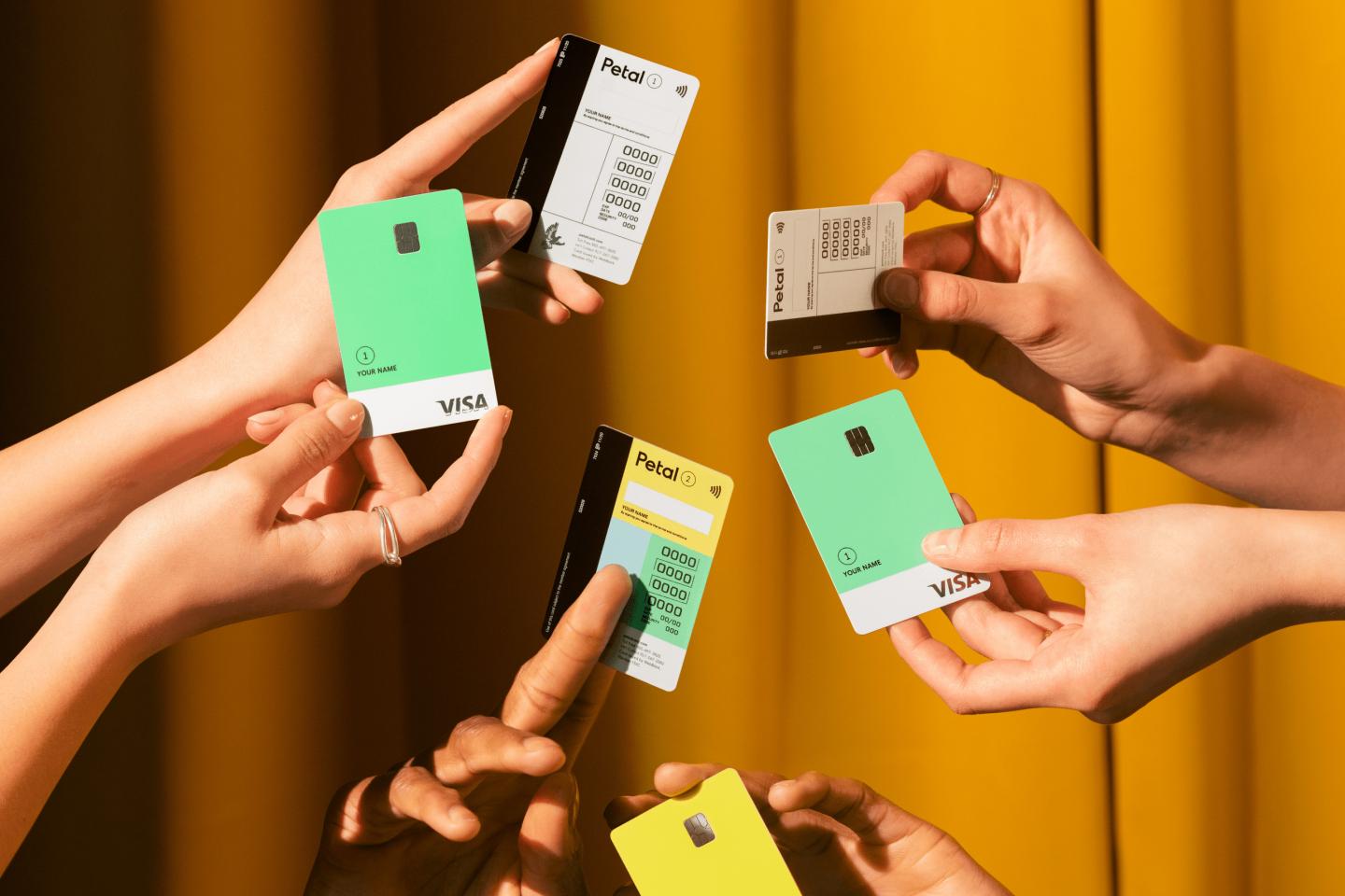 Hands holding up Petal Card credit cards.