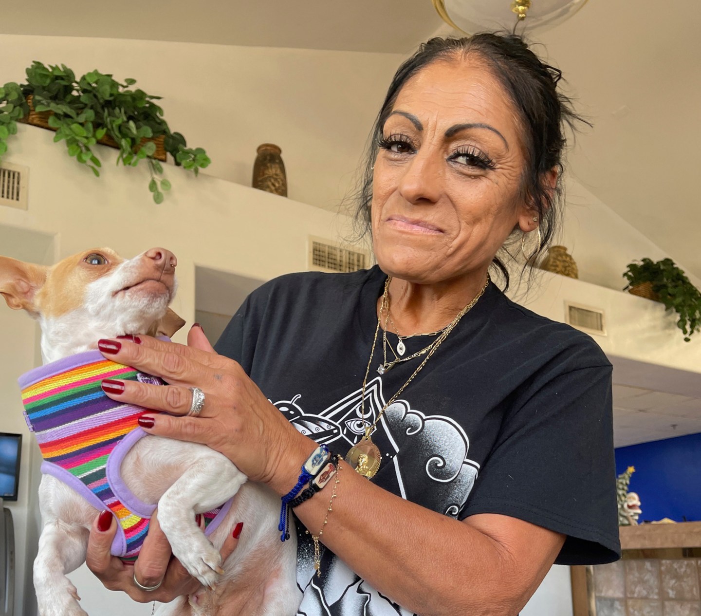 Angelita Saldaña shows off her pet Chihuahua Gaspar at a homeless shelter for older people in Phoenix, Nov. 28, 2023.