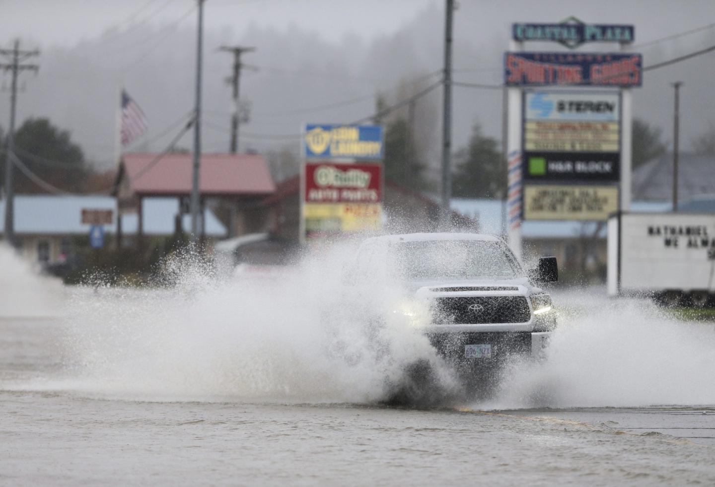 A car driving through water on a flooded highway