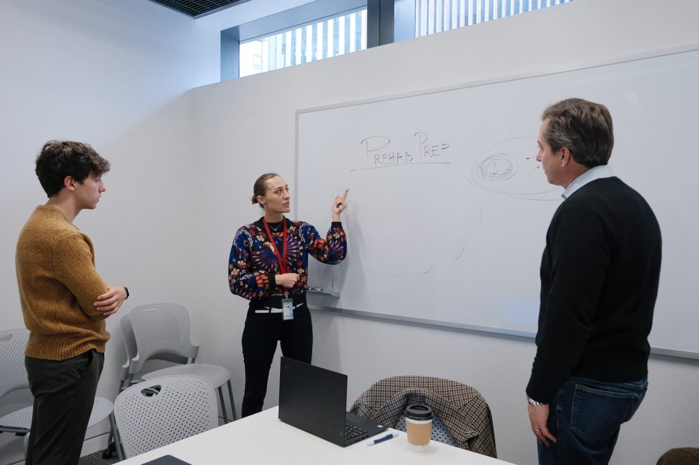 Students of Cornell Tech discuss business around a whiteboard