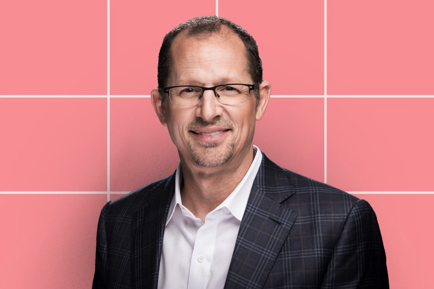 Coursera CEO Jeff Maggioncalda headshot is displayed in front of a pink-tiled background.