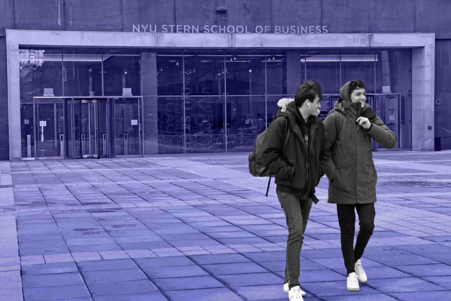 Photo of two students walking out of NYU Stern School of Business, talking and smiling.