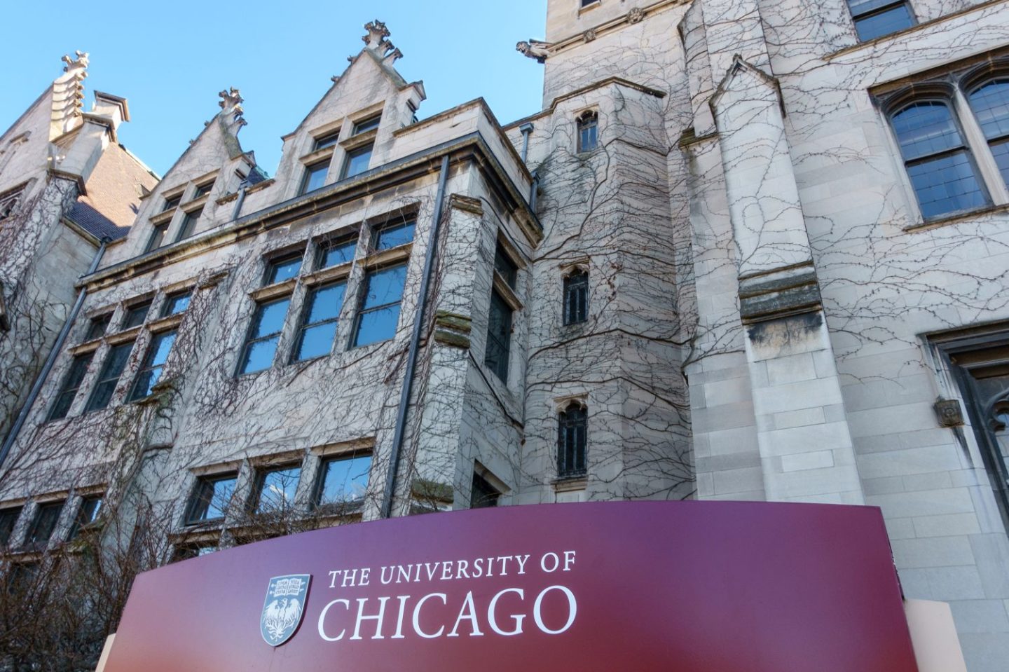 Photo of the University of Chicago sign in front of several campus buildings.