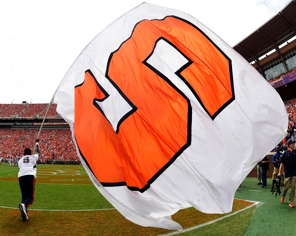 A Syracuse Orange cheerleader waves a giant Orange flag during their football game against the Clemson Tigers at Clemson Memorial Stadium, as seen in September 2018. (Photo by Mike Comer/Getty Images)