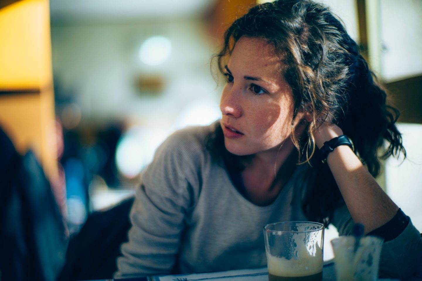 A young woman looking concerned in a coffee shop