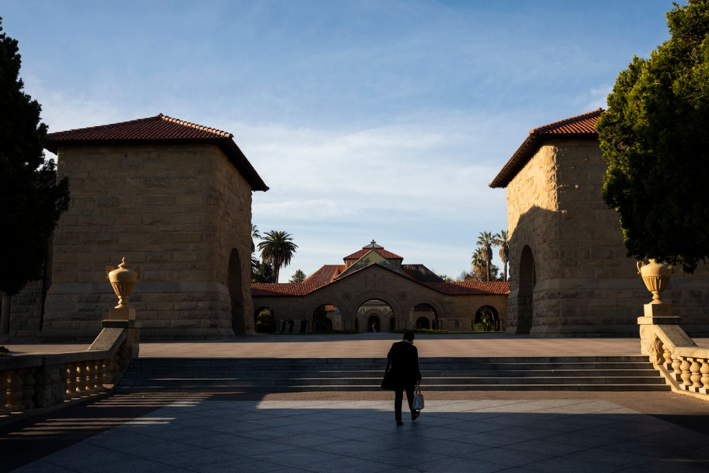A person walks toward the main quad during a quiet morning at Stanford University, as seen in March 2020. (Photo by Philip Pacheco/Getty Images)