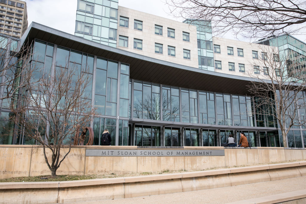 Pedestrians sit in front of the MIT Sloan School of Management building in Cambridge, Massachusetts, as seen in March 2020. (Photographer: Scott Eisen—Bloomberg/Getty Images)