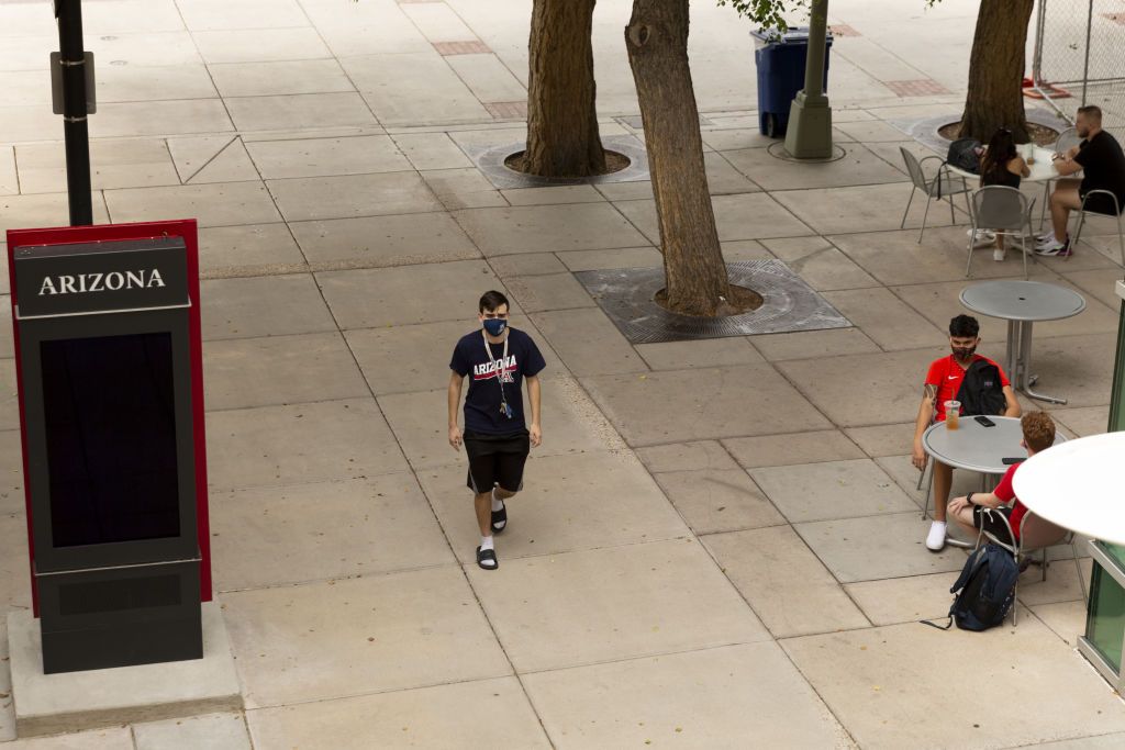 A student wears a protective mask while walking through the campus at the University of Arizona in Tucson, Arizona, as seen in August 2020. (Photographer: Cheney Orr—Bloomberg/Getty Images)
