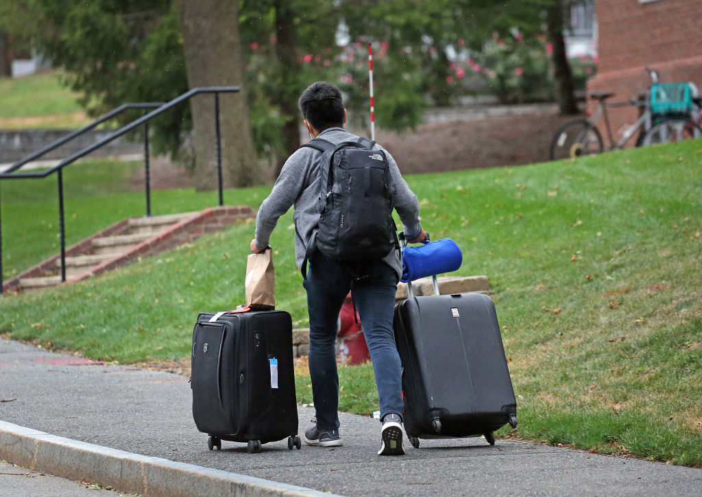 A student makes his way up to his dorm with his luggage on Talbot Avenue in Medford, MA, as seen in August 2020.