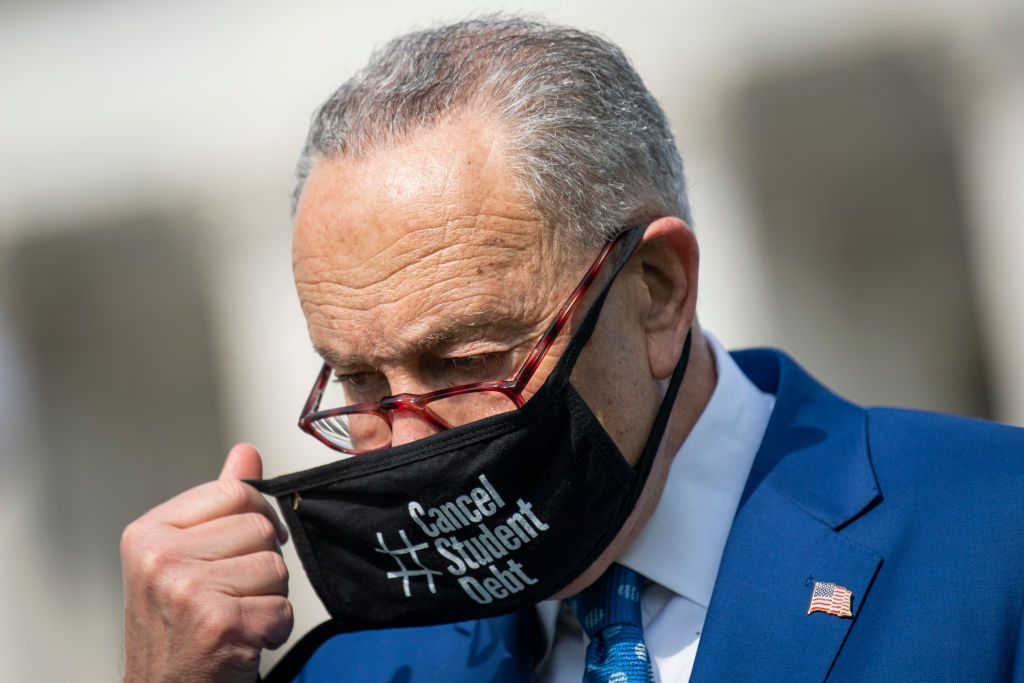 Senate Majority Leader Chuck Schumer (D-N.Y.) wears a face mask that reads #CancelStudentDebt, as seen April 2021. (Photo by Caroline Brehman—CQ-Roll Call/Getty Images)