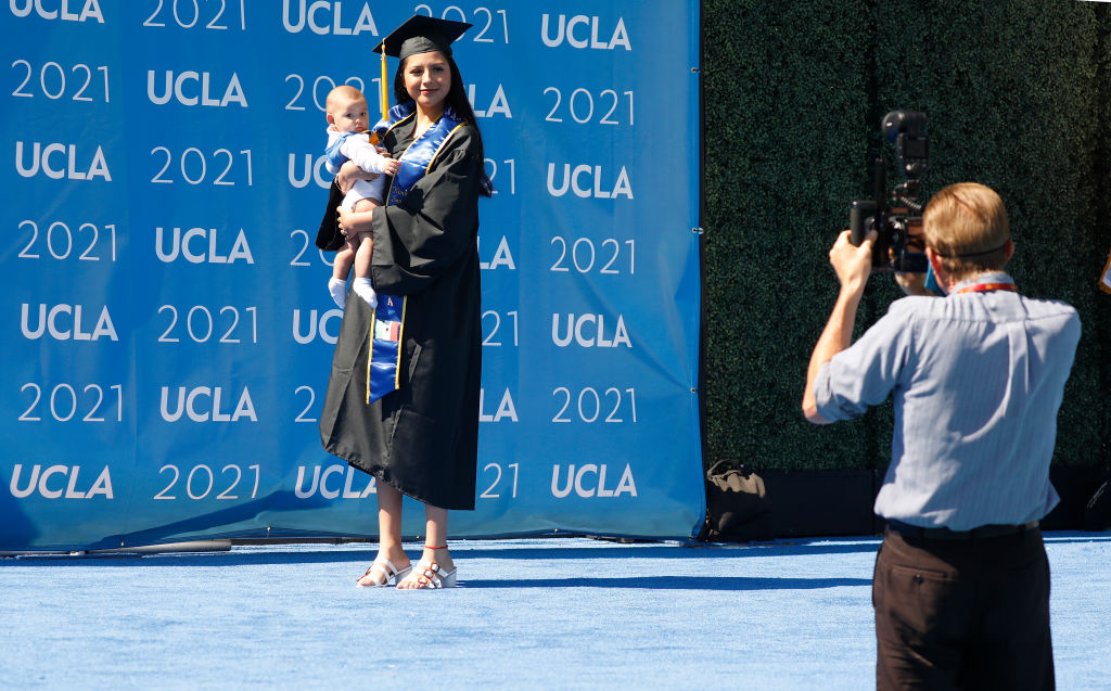 Kimberly Sanchez walks the stage holding her 6-month-old baby at a June 2021 graduation ceremony. (Al Seib—Los Angeles Times/Getty Images)